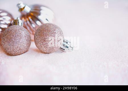 Decorazioni rosa natalizie scintillanti su uno strato o glitter. Messa a fuoco selettiva con sfondo sfocato e primo piano. Immagine scattata dalla vista superiore. Foto Stock