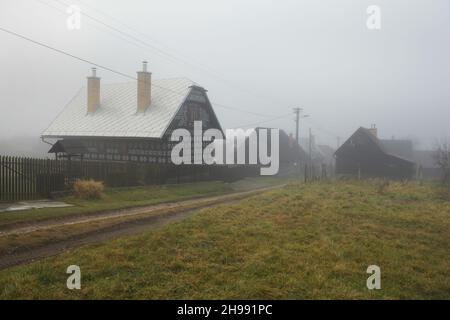 Case di tronchi tradizionali decorate con motivi lineari bianchi nel villaggio di Čičmany nella regione di Žilina, in Slovacchia. Foto Stock