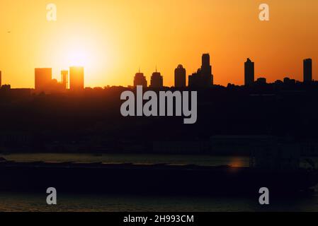 Tramonto dietro gli edifici di istanbul. Creazione di silhouette. La nave che attraversa il Bosforo. Foto Stock