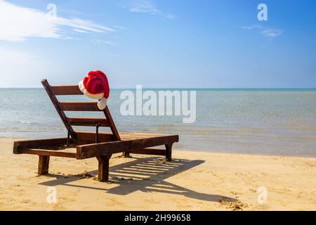 Cappello Babbo Natale sulla sedia lounge sulla spiaggia di mare Foto Stock