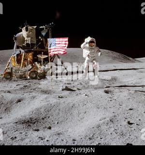L'astronauta John W. Young, comandante della missione di atterraggio lunare Apollo 16, sulla superficie lunare mentre saluta la bandiera degli Stati Uniti sul sito di atterraggio della luna durante la prima attività extraveicolare dell'Apollo 16 Foto Stock