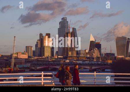 Londra, Regno Unito. 4 dicembre 2021. Le persone camminano a Waterloo Bridge passando per lo skyline della città di Londra, il quartiere finanziario della capitale. Credit: SOPA Images Limited/Alamy Live News Foto Stock