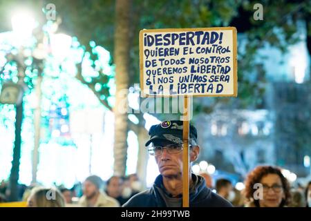 Valencia, Spagna. 4 dicembre 2021. Un manifestante tiene un cartello che dice 'libertà! Vogliono il controllo di tutti noi, vogliamo la libertà, se ci uniamo sarà la libertà 'durante la manifestazione.persone riunite alla Plaza del Ayuntamiento di Valencia per protestare contro il nuovo certificato Covid e la vaccinazione dei bambini. Credit: SOPA Images Limited/Alamy Live News Foto Stock