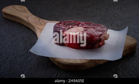 Taglio di osso buso grezzo su tagliere Foto Stock
