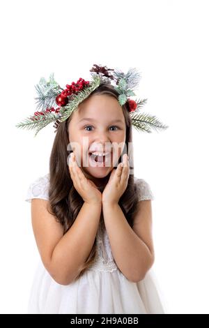 Ritratto di simpatica, affascinante ragazza con bocca aperta nella corona di Natale, sorpreso e in attesa di sorpresa per il Natale, isolato su bianco Foto Stock