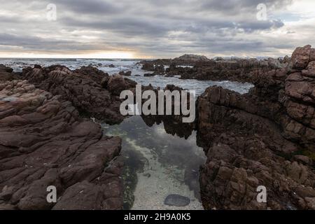 Formazioni rocciose e oceano, De Kelders, Capo Occidentale, Sudafrica. Foto Stock