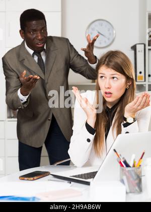 Uomo arrabbiato boss puntinting a mancate nel lavoro a donna manager di lavoro Foto Stock