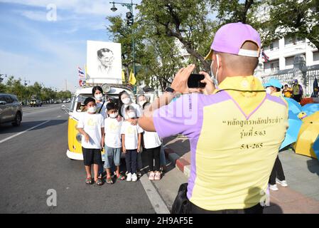 Bangkok, Tailandia. 5 dicembre 2021. Persone che sono fedeli a indossare camicie gialle e che mostrano le immagini dei monarchi thailandesi in attesa della processione reale del re thailandese su Ratchadamnoen Road, mentre la processione reale dell'auto passa al Grand Palace in occasione del compleanno di sua Maestà il tardo re Bhumibol Adulyadej il Grande, la Giornata Nazionale Tailandese e la Giornata del Padre della Thailandia. (Credit Image: © Teera Noisakran/Pacific Press via ZUMA Press Wire) Foto Stock
