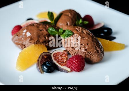 Primo piano di dessert al gelato al cioccolato con frutta Foto Stock