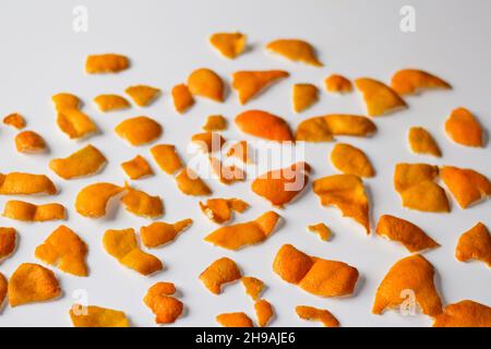 Sfocatura sfondo natalizio. Moderno e alla moda bucce di arancio e mandarino su sfondo bianco. Molti piccoli pezzi di buccia secca. Ripetizione. Isolato. O Foto Stock