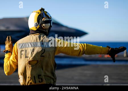 OCEANO PACIFICO (Nov. 29, 2021) Aviation Boatswain's Mate (Handling) Airman Julian Fernandp, di Yonkers, N.Y., dirige un F-35C Lightning II, assegnato ai 'Cavalieri neri' di Marine Fighter Attack Squadron (VMFA) 314, sul ponte di volo di USS Abraham Lincoln (CVN 72). Abraham Lincoln sta conducendo le operazioni di routine nella terza flotta degli Stati Uniti. (STATI UNITI Foto Navy di Mass Communication Specialist terza classe Michael Singley/rilasciato) Foto Stock