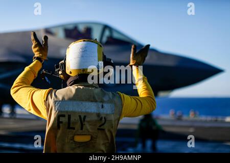 OCEANO PACIFICO (Nov. 29, 2021) Aviation Boatswain's Mate (Handling) Airman Julian Fernandp, di Yonkers, N.Y., dirige un F-35C Lightning II, assegnato ai 'Cavalieri neri' di Marine Fighter Attack Squadron (VMFA) 314, sul ponte di volo di USS Abraham Lincoln (CVN 72). Abraham Lincoln sta conducendo le operazioni di routine nella terza flotta degli Stati Uniti. (STATI UNITI Foto Navy di Mass Communication Specialist terza classe Michael Singley/rilasciato) Foto Stock