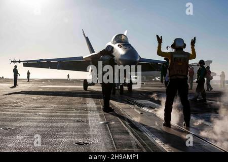 OCEANO PACIFICO (Nov. 29, 2021) Aviation Boatswain's Mate (Handling) Airman Julian Fernandp, di Yonkers, N.Y., dirige un F/A-18E Super Hornet, assegnato ai 'Tophatters' di Strike Fighter Squadron (VFA) 14, sul ponte di volo di USS Abraham Lincoln (CVN 72). Abraham Lincoln sta conducendo le operazioni di routine nella terza flotta degli Stati Uniti. (STATI UNITI Foto Navy di Mass Communication Specialist terza classe Michael Singley/rilasciato) Foto Stock