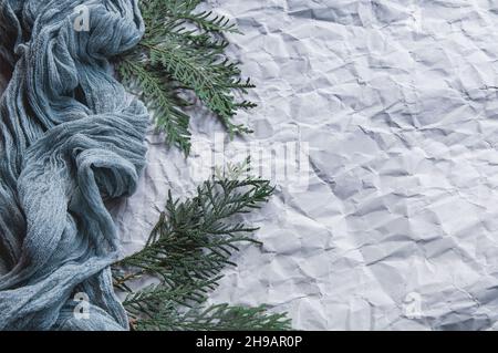 Tovaglie di garza su sfondo grigio con sprigs di abete, cursore di scorrimento a garza blu su sfondo leggermente sgualcito Foto Stock