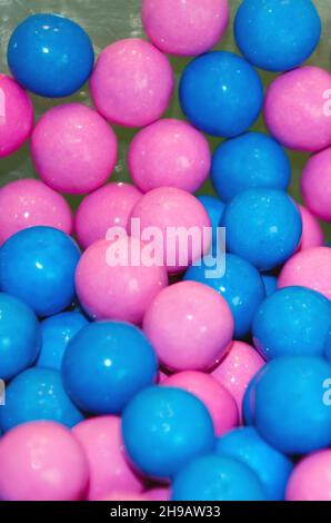 primo piano di bubblegum rosa e blu ad una festa di compleanno per i gemelli ragazzo e ragazza Foto Stock