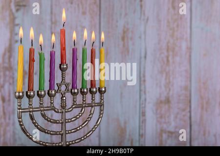 Menorah festivo Ebraico con candele brucianti per Hanukkah con candele colorate. Foto Stock