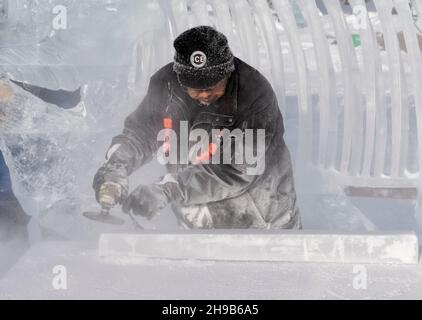 Artista che lavora alla scultura del ghiaccio durante il Festival della magia del ghiaccio, Lake Louise, Banff National Park, Alberta, Canada Foto Stock