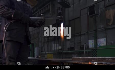 Il saldatore lavora in fabbrica su una struttura metallica. Clip. Lavori di saldatura con metallo in fabbrica. Impianti metallurgici e lavori di saldatura. Foto Stock