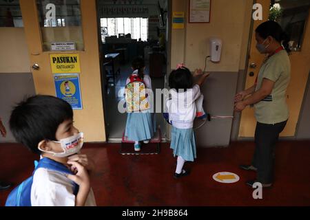 6 dicembre 2021: Gli studenti si lavano le mani con alcol prima di frequentare lezioni di persona in una scuola elementare a Makati City, Metro Manila, Filippine. 6 dicembre 2021. Circa 28 scuole nella capitale filippina hanno iniziato a condurre classi limitate faccia a faccia con rigorosi protocolli sanitari per prevenire la diffusione di COVID-19. (Credit Image: © Basilio Sepe/ZUMA Press Wire) Foto Stock