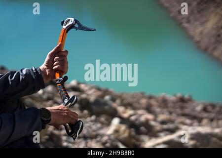 Arrampicatore con l'ascia di ghiaccio in montagna. Foto Stock