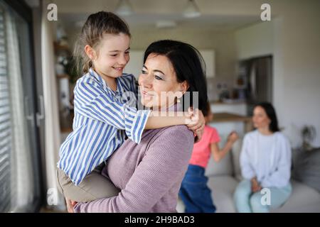 Piccola ragazza felice con nonna senior al coperto a casa divertirsi. Foto Stock