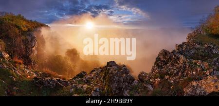 Valle di montagna durante l'alba. Paesaggio naturale estivo con nebbia Foto Stock