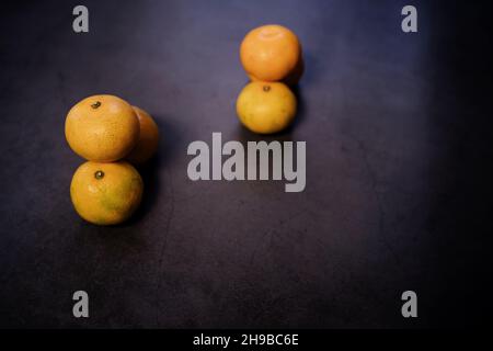 Sei tangerini su tavola scura, clementine, agrumi, fuoco selettivo Foto Stock