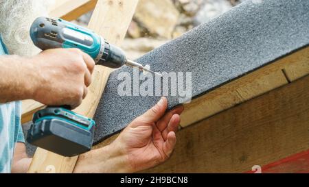 Uomo che usa una vite sul feltro di copertura Foto Stock