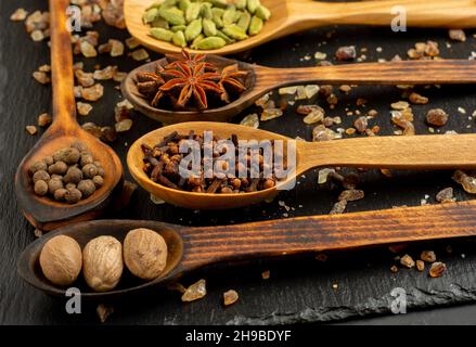 Selezione di spezie su tavola di legno scuro. Cibo o concetto di cottura speziato, mangiare sano sfondo. Foto Stock