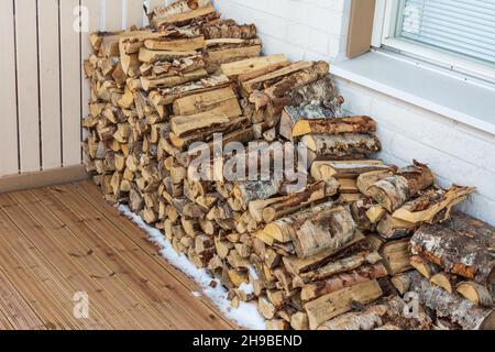 Legna da ardere tagliata e accatastata in terrazza sul cortile d'inverno a Rovaniemi Finlandia Foto Stock