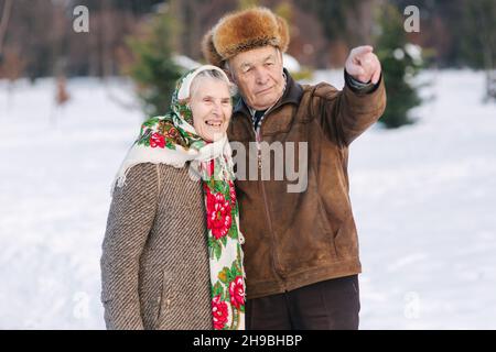 Le coppie anziane si rilassano in inverno nel parco. Nonno felice e nonna che camminano insieme Foto Stock