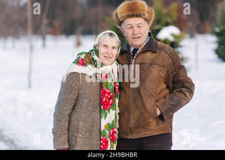 Le coppie anziane si rilassano in inverno nel parco. Nonno felice e nonna che camminano insieme Foto Stock