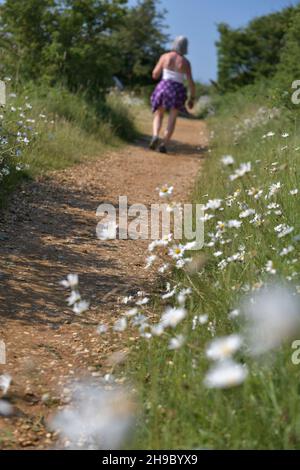 donne sole che camminano lungo la corsia rurale di campagna Foto Stock