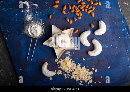 Macaroni alla vaniglia a forma di mezzaluna in zucchero a velo su sfondo blu Foto Stock