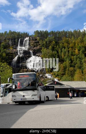 Pullman turistici alla cascata di Tvindefossen, Norvegia, che portano i turisti a vedere la cascata Foto Stock