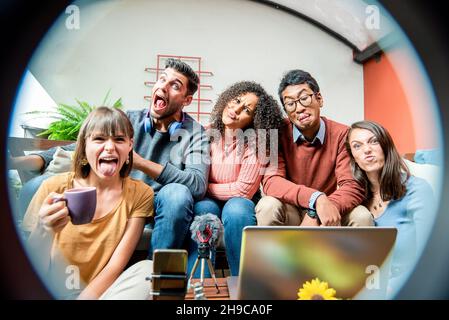 Buon giovane blogger smart filmare nuovo video vlog con smartphone, luce ad anello e laptop a casa, giovani divertirsi e trasmettere il loro blog Foto Stock