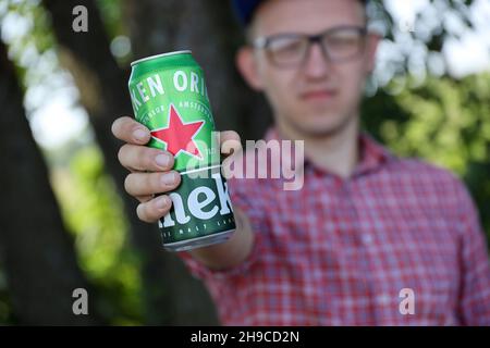 KHARKOV, UCRAINA - 31 LUGLIO 2021: Uomo con lattina verde di birra chiara di Heineken prodotta dalla birreria olandese Heineken N.V. Foto Stock