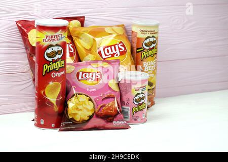 KHARKOV, UCRAINA - 3 GENNAIO 2021: Vari aromatizzati di patatine fritte di patata di Lay's e Pringles nel design classico delle confezioni. Marche di patate famose in tutto il mondo Foto Stock