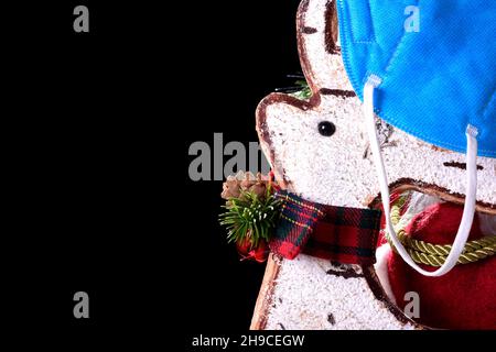 Fotografia di un primo piano di un ornamento di Natale con un tipico arco rosso e un blu appeso mask.The foto cerca di dire che questo Natale non per Foto Stock