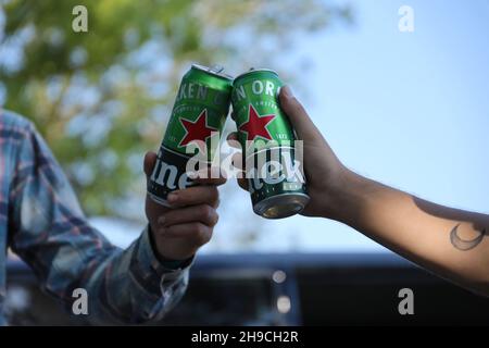 KHARKOV, UCRAINA - 31 LUGLIO 2021: Lattine di Heineken birra lager pallido nelle mani degli uomini all'aperto Foto Stock