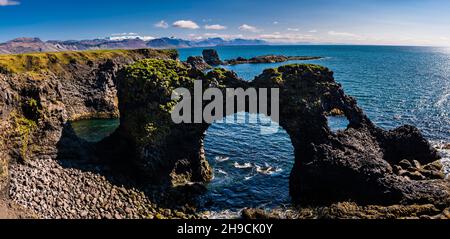 Vista panoramica delle rocce e dei fori del Gatklettur presso le scogliere di Arnarstapi, la penisola di Snaefelsnes, Islanda Foto Stock