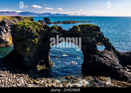 Foro circolare nelle rocce di Gatklettur alle scogliere di Arnarstapi, Penisola di Snaefellsnes, Islanda Foto Stock