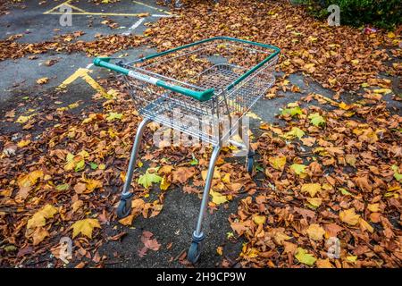 Carrello vuoto abbandonato Morrisons shopping buttato in un parcheggio auto con le foglie autunnali sul pavimento preso il 7 novembre 2021 a Sidcup sud-est di Londra Foto Stock