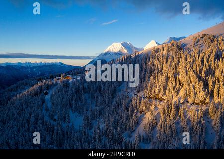 Sera paesaggio invernale in montagna, pineta al tramonto. Colline innevate. Piste da sci di fondo innevate, Krvavec, Slovenia Foto Stock