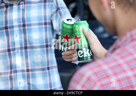 KHARKOV, UCRAINA - 31 LUGLIO 2021: Lattine di Heineken birra lager pallido nelle mani degli uomini all'aperto Foto Stock