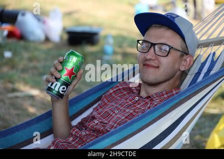 KHARKOV, UCRAINA - 31 LUGLIO 2021: Uomo con lattina verde di birra chiara di Heineken prodotta dalla birreria olandese Heineken N.V. Foto Stock