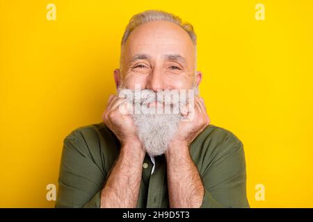 Ritratto di uomo anziano in camicia verde sorridente allegro isolato colore giallo brillante sfondo Foto Stock