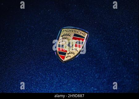 Riga, Lettonia, Sep 24, 2021: Vista del logo della società Porsche sul cofano della vettura blu, primo piano Foto Stock