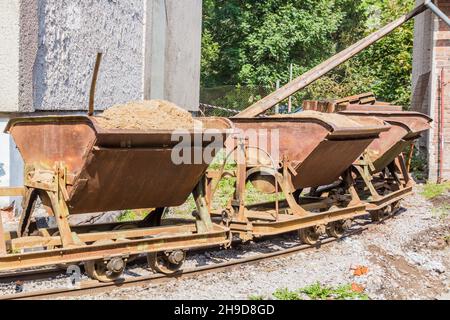 Macchine a tramoggia per ferrovia caricate con sabbia in una vecchia fabbrica Foto Stock