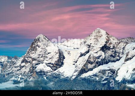 Romantico cielo rosa al tramonto sopra le cime di Eiger e Monch ricoperte di neve, Murren Birg, Jungfrau Region, Berna, Svizzera Foto Stock